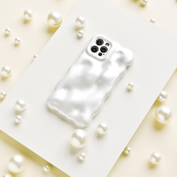 The 3D Pearl Phone Case - White from Coconut Lane, featuring a wavy texture and a glossy pearl white finish, is placed on a flat white surface surrounded by scattered pearls of various sizes. The case has precise openings for the camera and sensors at the top.