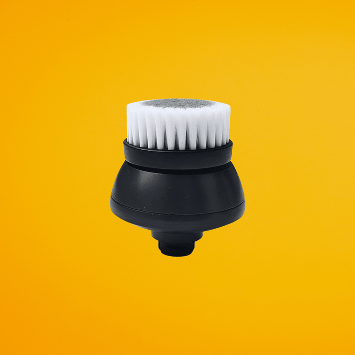 Close-up view of the white bristle cleansing brush head accessory for scalp care.