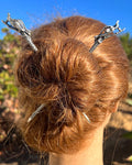 "Model wearing silver dragon hair sticks styled in a twisted bun hairstyle with fantasy-inspired hair accessories