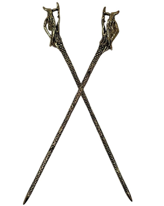Gold textured metal Dragon Hair Sticks crossed in a front view on a white background