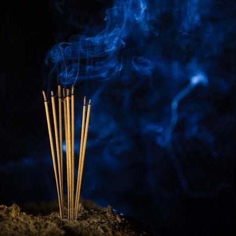 Burning incense sticks set, thin light-brown sticks with blue smoke