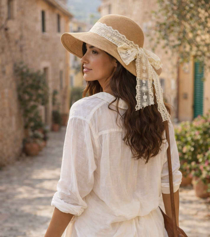 Straw sun hat with wide brim, lace ribbon trim, and dangling tails on back