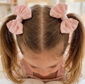 Child with pink hair bows in pigtails