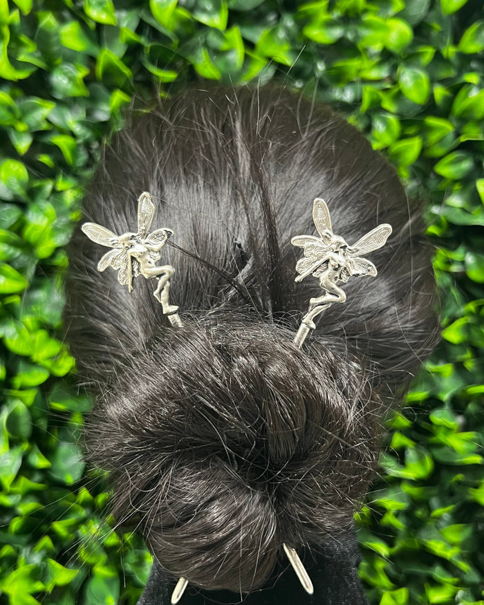 Model wearing SilverFairy Hair Sticks featuring winged fairy design, decorative fantasy hair pins styled in a twisted bun for women.