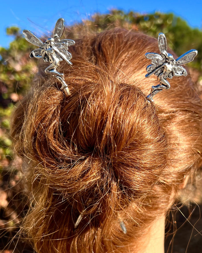 Model wearing Silver Fairy Hair Sticks featuring winged fairy design, decorative fantasy hair pins styled in a twisted bun for women.