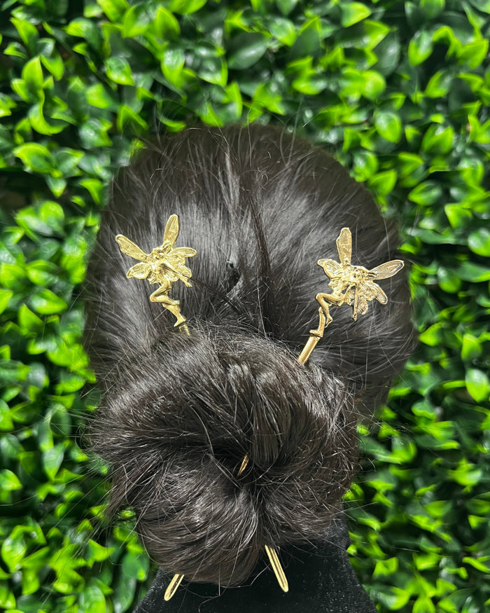 Model wearing Gold Fairy Hair Sticks featuring winged fairy design, decorative fantasy hair pins styled in a twisted bun for women.