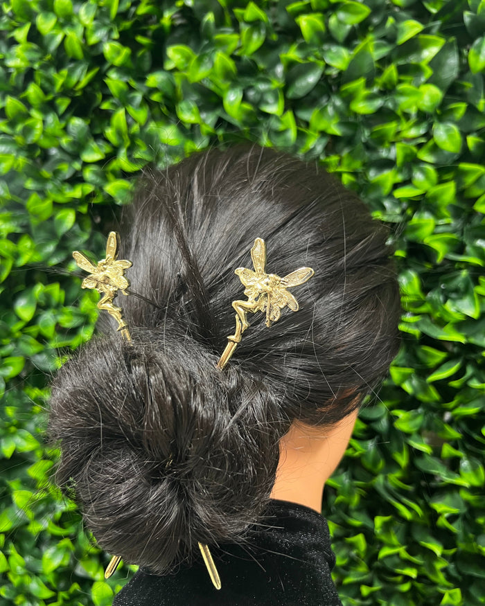 Model wearing Gold Fairy Hair Sticks with winged fairy design in a twisted bun hairstyle, fantasy hair accessory for women.