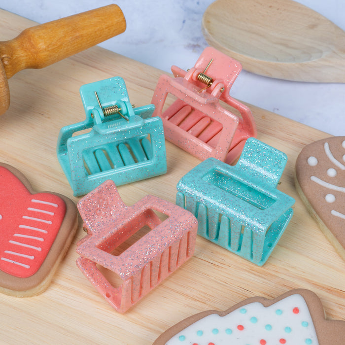 Colorful hair clips on a wooden surface with decorative cookies.