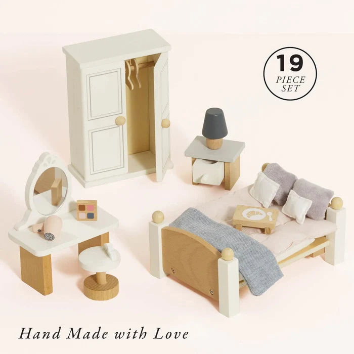 Wooden dollhouse furniture set with a bed, dresser, and vanity on a light pink background.