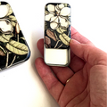 Floral-patterned tin box held by a hand.
