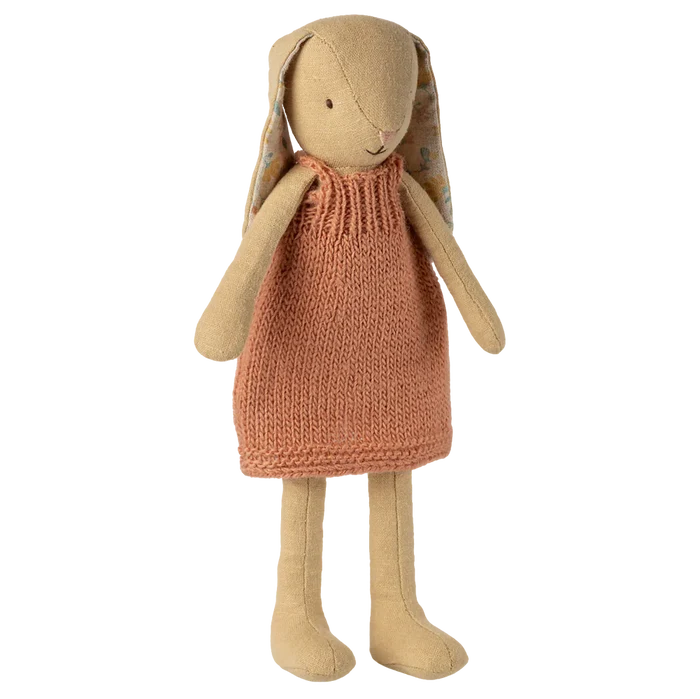 Toy rabbit with a knitted dress on a white background