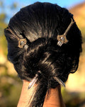 Model wearing Medieval Sword Hair Sticks in a twisted bun hairstyle, sword-inspired fantasy hair accessories for women.