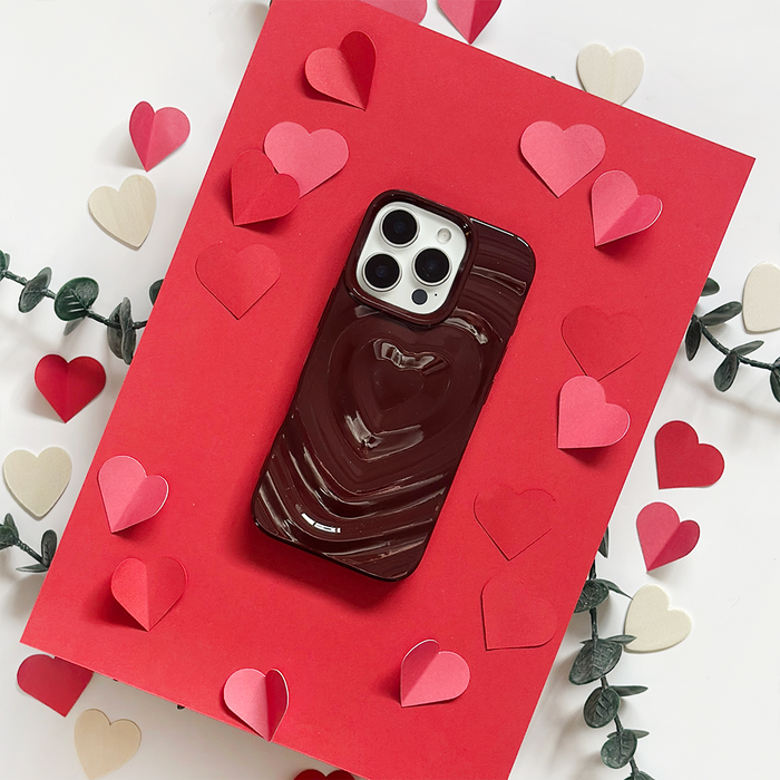Burgundy Coconut Lane phone case with melting heart design on a red card, decorated with paper hearts and green leaves.