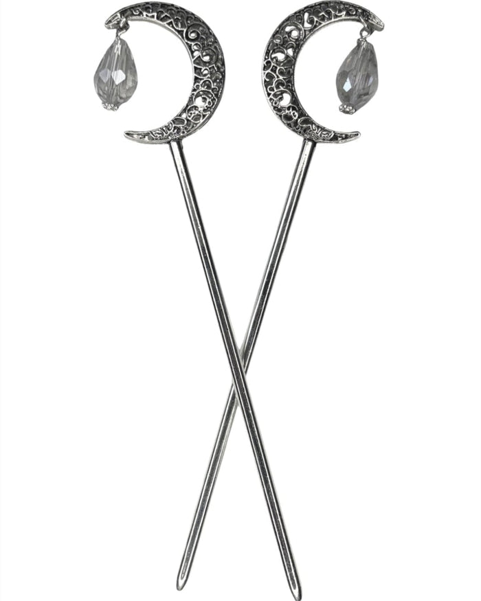 Pair of silver crescent moon hair sticks with clear crystal teardrop dangles, shown crossed on a white background to display the front view and celestial moon design.