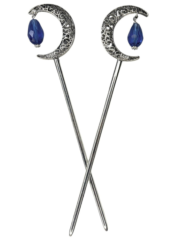 Pair of silver crescent moon hair sticks with blue crystal teardrop dangles, shown crossed on a white background to display the front view and celestial moon design.