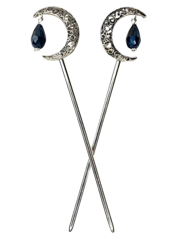 Pair of silver crescent moon hair sticks with black crystal teardrop dangles, shown crossed on a white background to display the front view and celestial moon design.