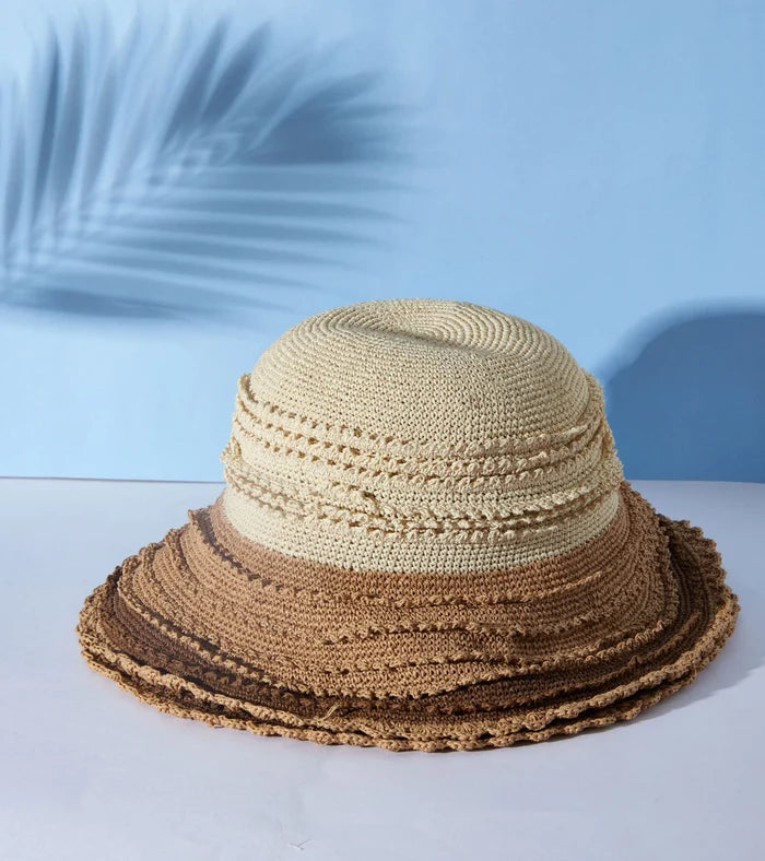 Beige paper straw hat with tan trim, braided crown and wide brim