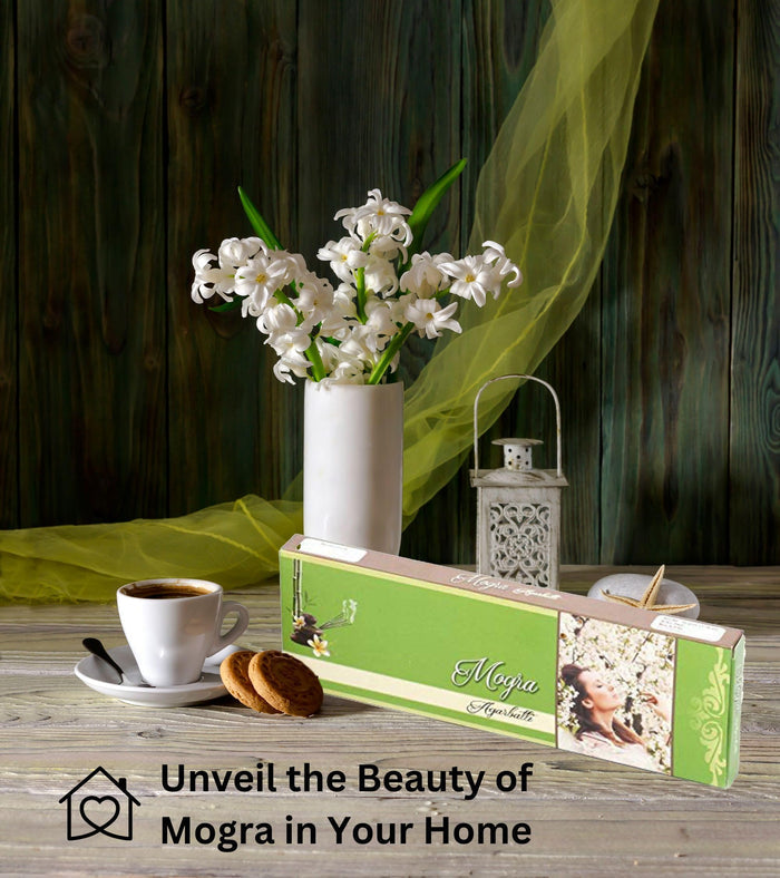Mogra agarbatti incense stick pack with floral artwork, displayed beside a lit incense holder
