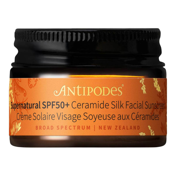 Antipodes sunscreen jar with orange label on a white background.