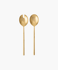 Two elegant, matte gold salad servers on a white background. One has a forked design, the other a smooth, rounded bowl. Minimalist and luxurious tone. | Wildwood Home Co.