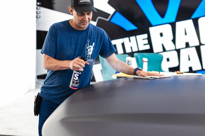 Person spraying P&S Triple S onto the hood of a car.