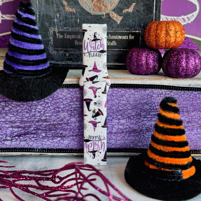 Close-up of the Witch Please Fitbit Versa 1/2 band showing purple, black and navy witch hats with grey spiderwebs.