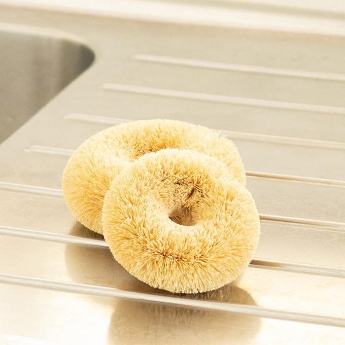 2 plastic free, coconut fibre scourers sitting on a counter.