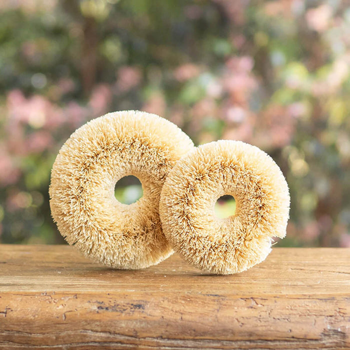 2 plastic free, coconut fibre scourers sitting on a counter.